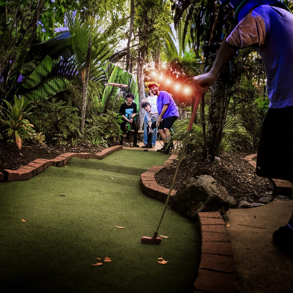 People playing twilight mini golf